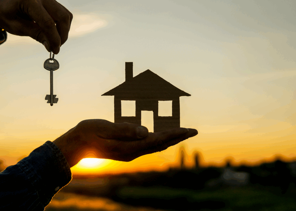 On aperçois une maison qui tient une maquette en forme de maison, dans son autre main la personne tient des clés