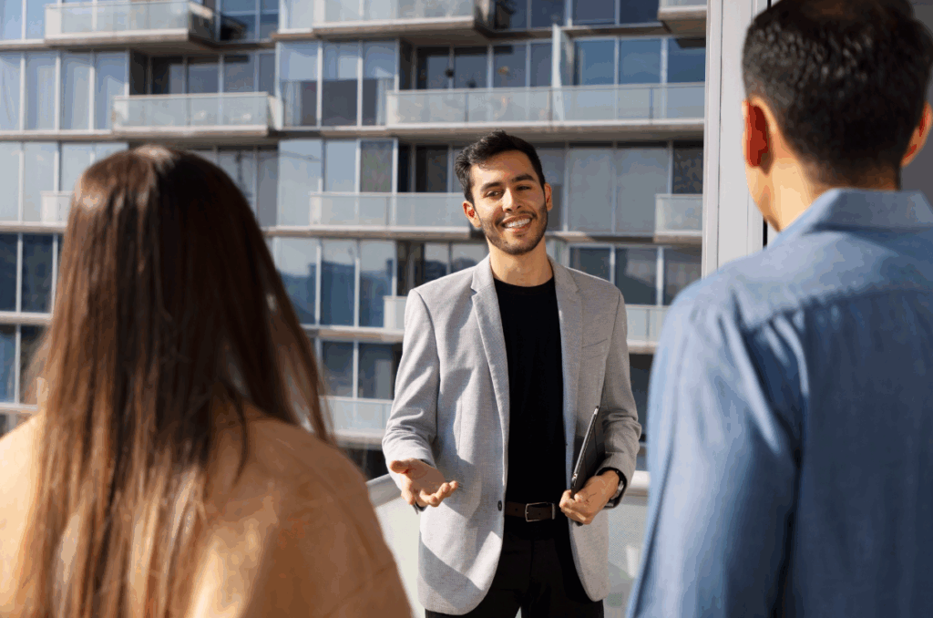 On aperçoit un homme en costard qui discute avec un couple