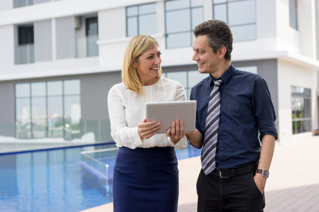 Heureux partenaires commerciaux, lire des nouvelles sur une tablette à l'extérieur.